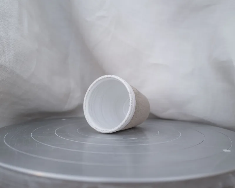graue Tasse mit weisser Glasur, liegend